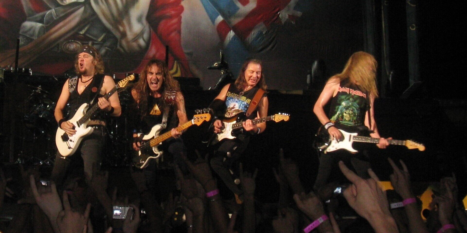 Iron_Maiden_in_performance_picby_derivative_work_Javatyk_CC four men with guitars